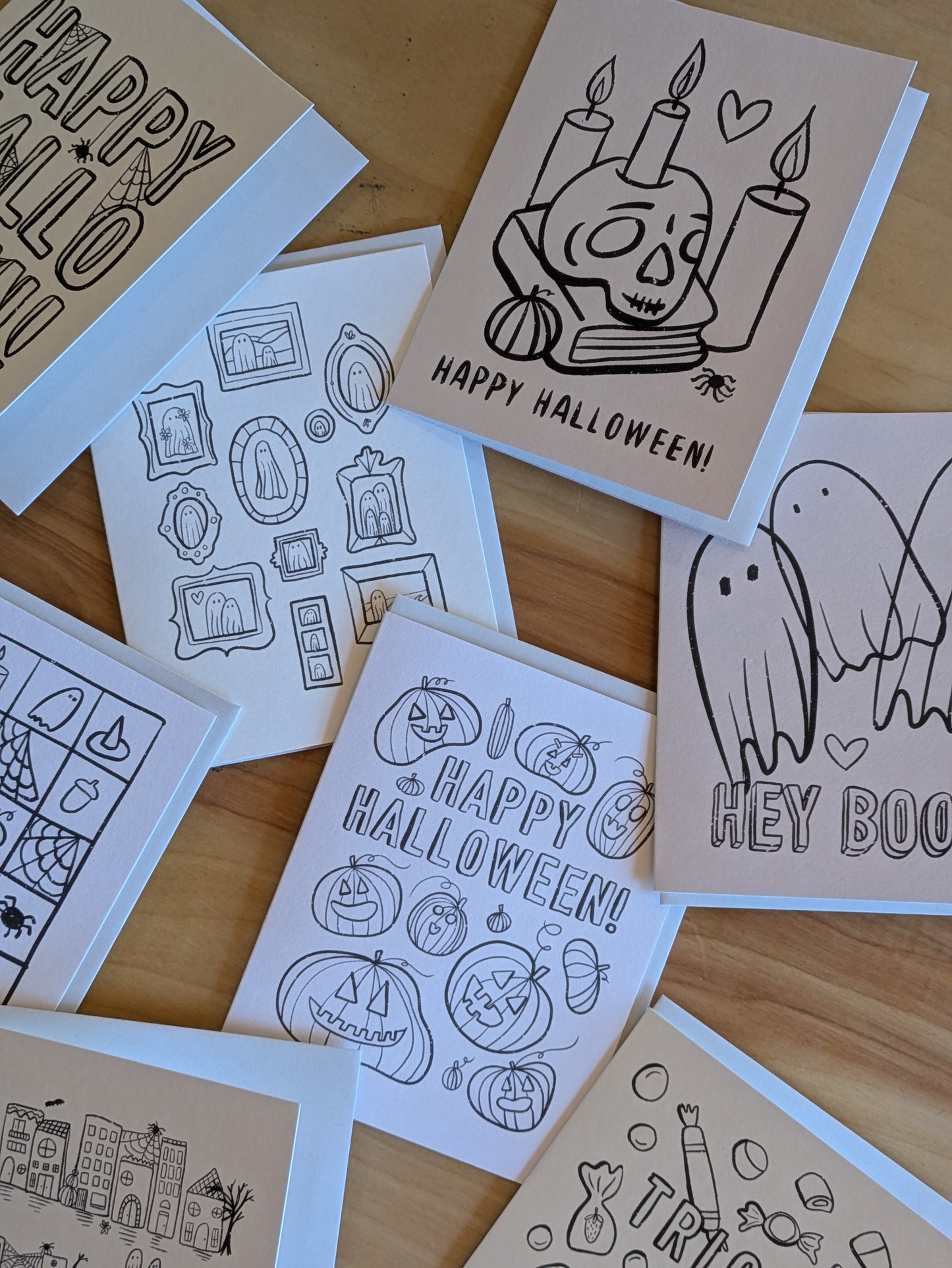 Collection of Halloween-themed greeting cards on a wooden surface